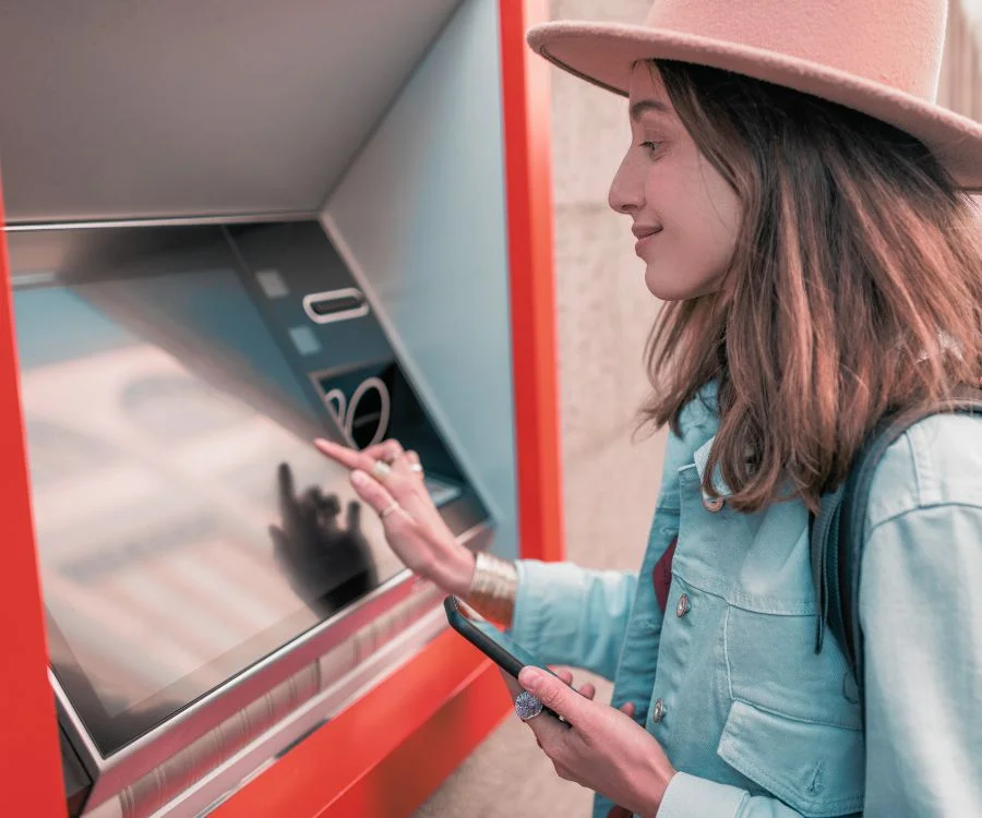 Image of a girl using atm machine.