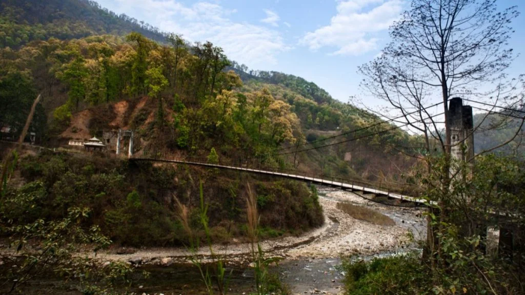 Image of a quaint bridge connecting two valleys divided by a river.